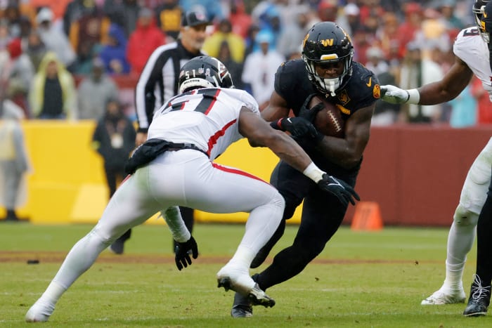 Washington Commanders running back Brian Robinson Jr. (8) carries the ball as Atlanta Falcons linebacker DeAngelo Malone (51) defends during the third quarter at FedExField.